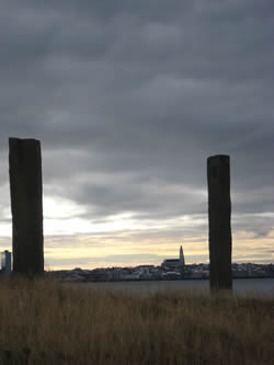 View of Reykjavík (and Hallgrímskirkja) from the West island of Viðey. The two basalt pillars in the foreground are part of Richard Serra's installation 'Áfangar,' ('Milestones') which 'frame' various landmarks and sites around the islan