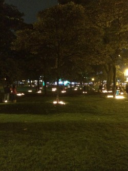 Families lighting candles in the park to celebrate Día de las Velitas